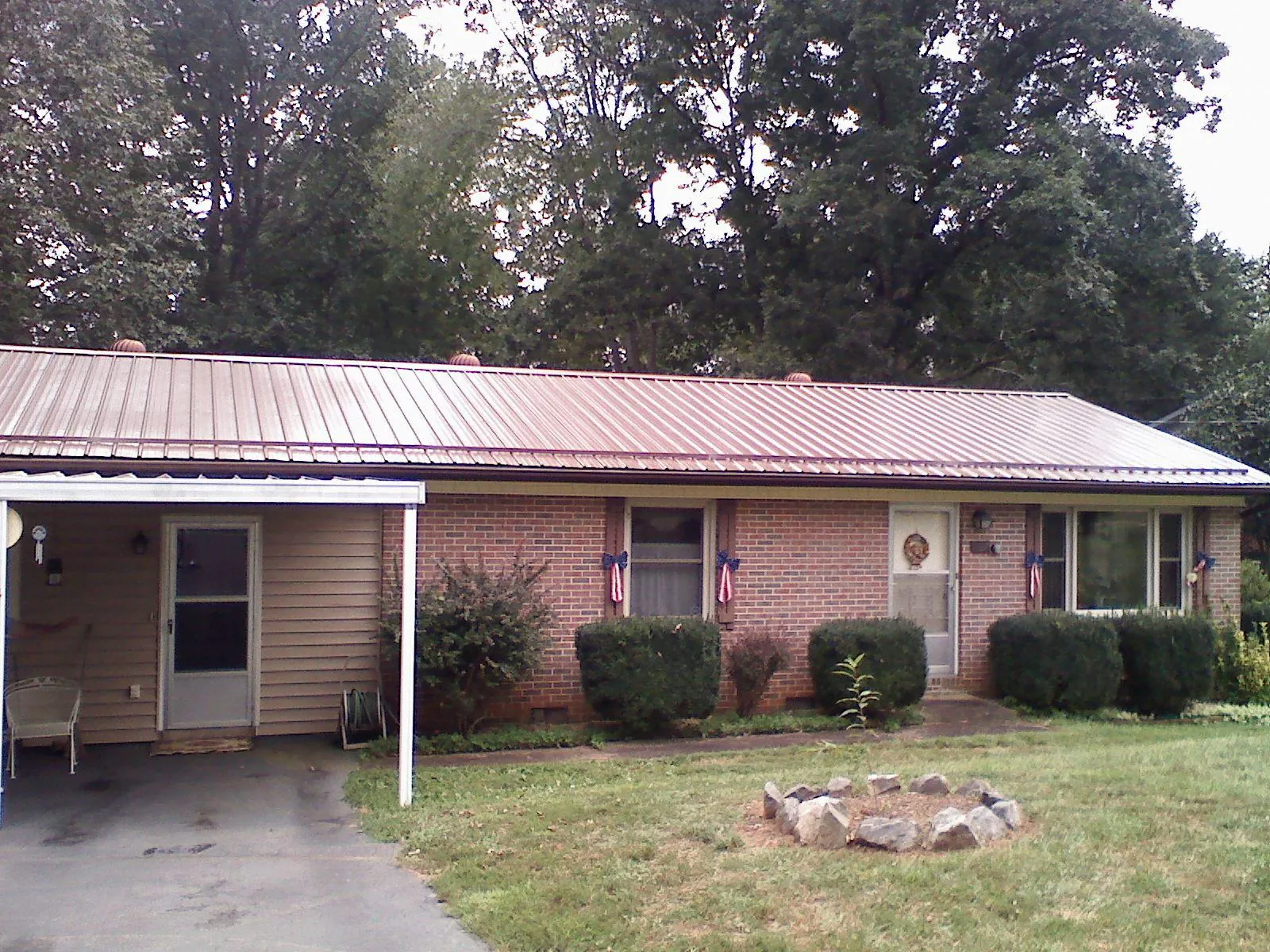 Bronze metal roof and carport on a brick ranch home — Roof Repair work by our crew in Palouse